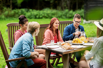 Image showing happy friends having dinner at summer garden party