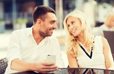 Image showing happy couple with smatphone at city street cafe