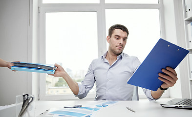 Image showing businessman taking papers from secretary in office