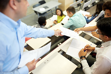 Image showing teacher giving tests to students at lecture hall