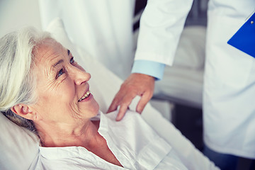 Image showing doctor visiting happy senior woman at hospital