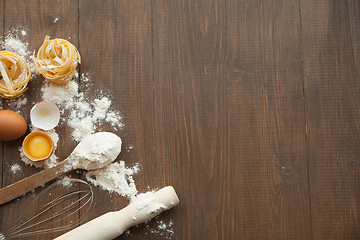 Image showing Cuisine composition with cracked eggs,kitchenware, flour.