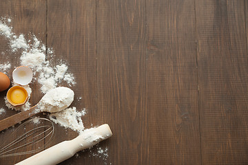 Image showing Cuisine composition with cracked eggs,kitchenware, flour.