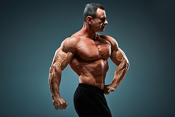 Image showing torso of attractive male body builder on gray background.