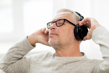 Image showing happy man in headphones listening to music at home