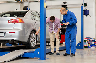 Image showing auto mechanic with clipboard and man at car shop