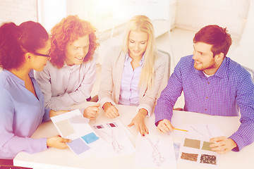 Image showing smiling creative team looking at sketch