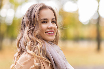 Image showing beautiful happy young woman smiling in autumn park