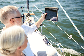 Image showing senior couple with tablet pc on sail boat or yacht