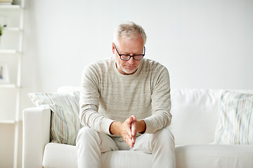 Image showing  senior man sitting on sofa at home and thinking