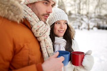 Image showing close up of happy couple with tea cups in winter