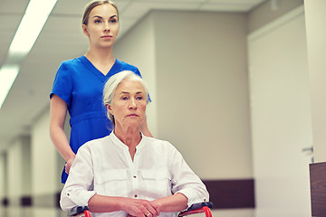 Image showing nurse with senior woman in wheelchair at hospital