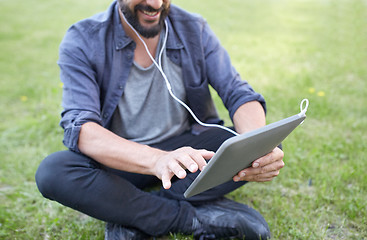 Image showing close up of man with tablet pc and earphones