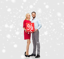 Image showing happy couple with red sale sign over snow