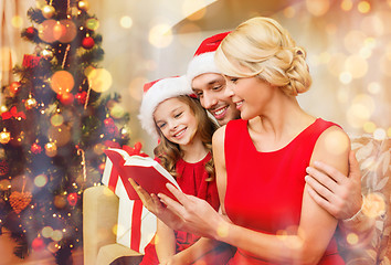 Image showing smiling family reading book