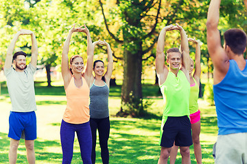 Image showing group of friends or sportsmen exercising outdoors