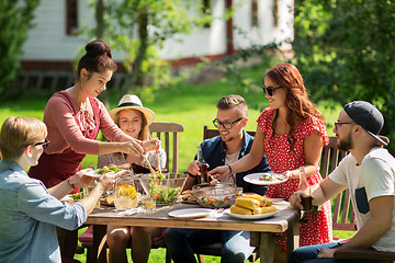 Image showing happy friends having dinner at summer garden party