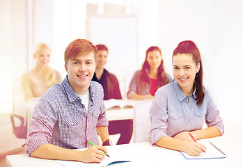 Image showing smiling students with notebooks at school