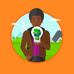 Image showing Man holding light bulb with tree inside.