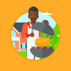 Image showing Man cooking chicken on barbecue grill.