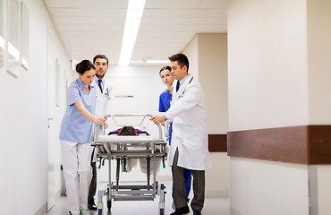 Image showing medics with woman on hospital gurney at emergency