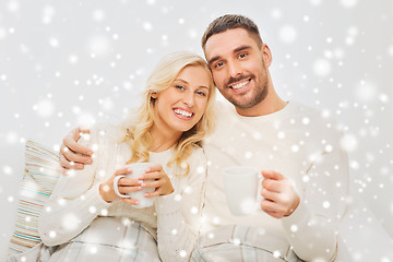 Image showing happy couple with cups drinking tea at home