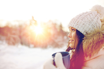 Image showing happy young woman with tea cup outdoors in winter