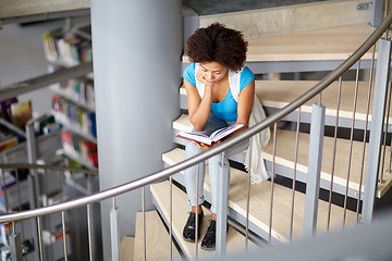 Image showing african student girl reading book at library