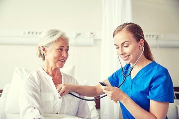 Image showing nurse with stethoscope and senior woman at clinic