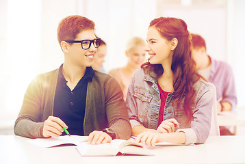 Image showing two teenagers with notebooks and book at school