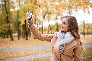 Image showing woman taking selfie by smartphone in autumn park