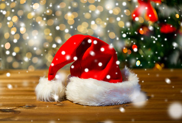 Image showing close up of santa hat on wooden table over lights
