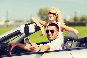 Image showing happy couple in car taking selfie with smartphone