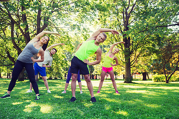 Image showing group of friends or sportsmen exercising outdoors