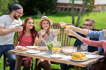 Image showing happy friends having dinner at summer garden party