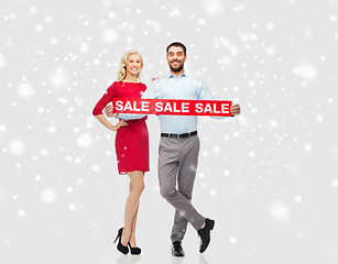 Image showing happy couple with red sale sign over snow