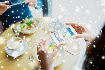 Image showing close up of couple picturing food by smartphone