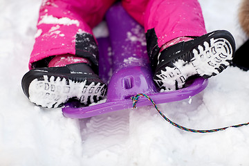 Image showing close up of kids feet in winter boots on sled