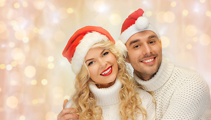 Image showing happy family couple in sweaters and santa hats