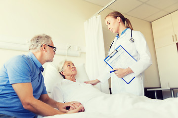 Image showing senior woman and doctor with clipboard at hospital