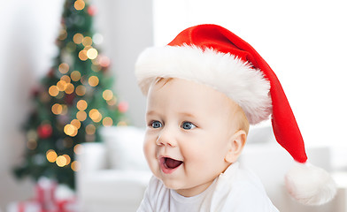 Image showing baby boy in christmas santa hat over blue lights