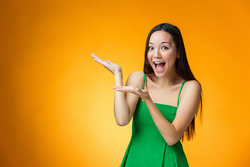 Image showing The happy Chinese girl on yellow background