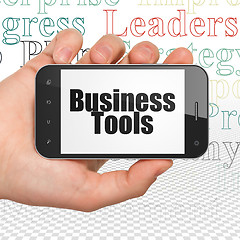 Image showing Finance concept: Hand Holding Smartphone with Business Tools on display