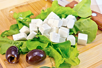 Image showing Feta with olives and green lettuce on board