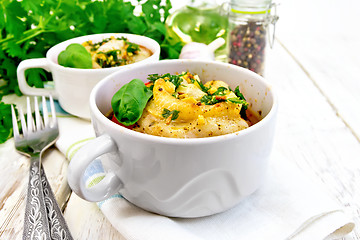 Image showing Fish baked with tomato in white bowl on napkin