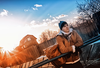 Image showing Tourist In The Village Against The  Rays Of The Setting Sun