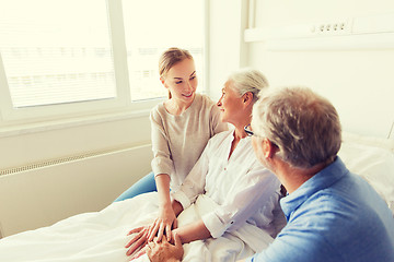 Image showing happy family visiting senior woman at hospital