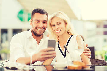 Image showing happy couple taking selfie with smatphone at cafe