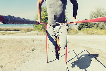 Image showing young man exercising on parallel bars outdoors