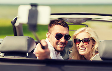 Image showing happy couple in car taking selfie with smartphone